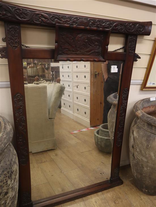 A late 19th century Chinese style carved hardwood mirror, decorated with a phoenix, clouds and foliage H.136cm